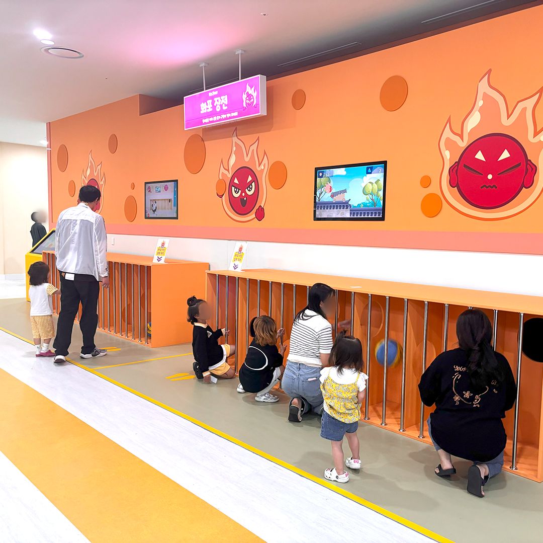 화포 장전 게임기 앞에서 플레이하는 아이와 가족