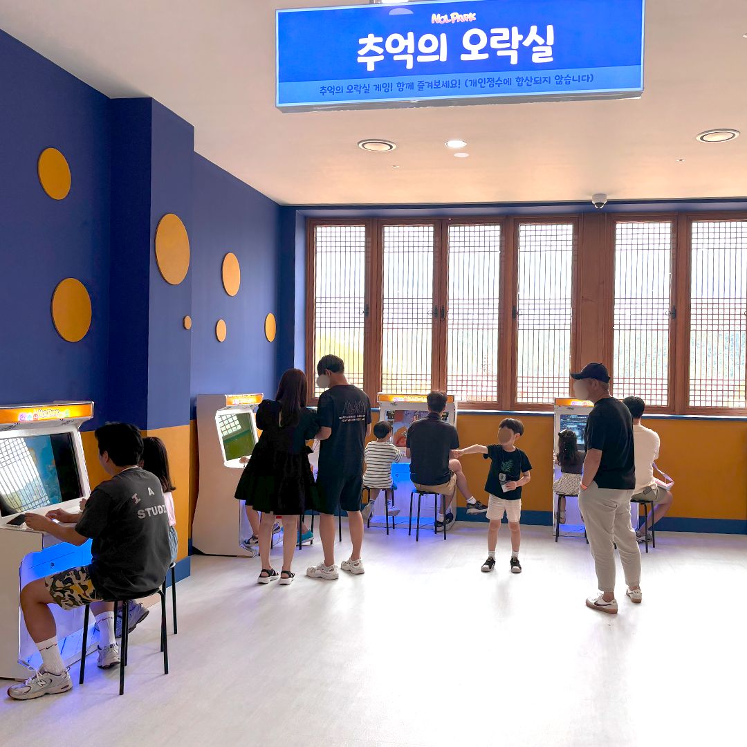추억의 오락실에서 게임을 하는 방문객들