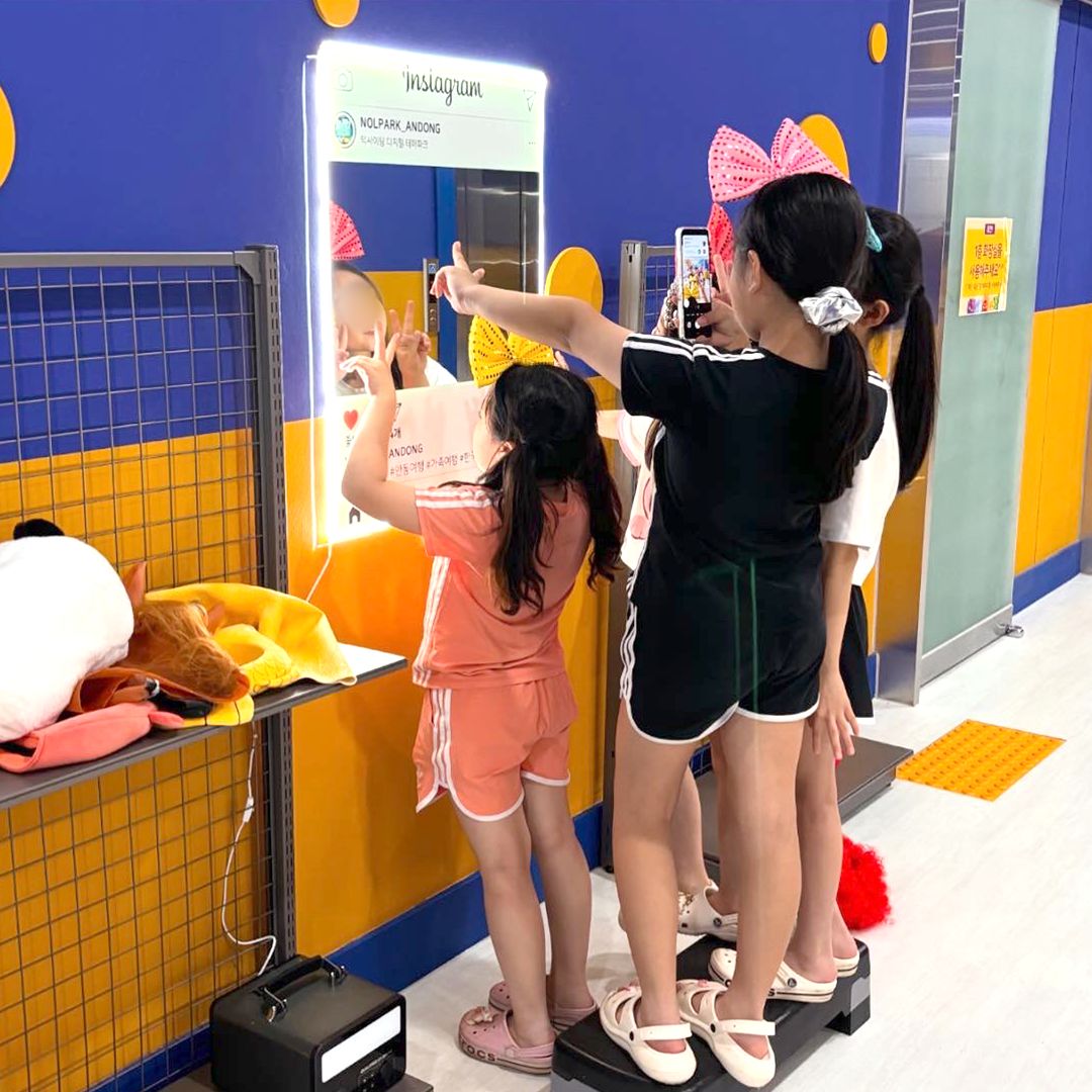 포토존 거울 앞에서 사진을 찍는 아이들